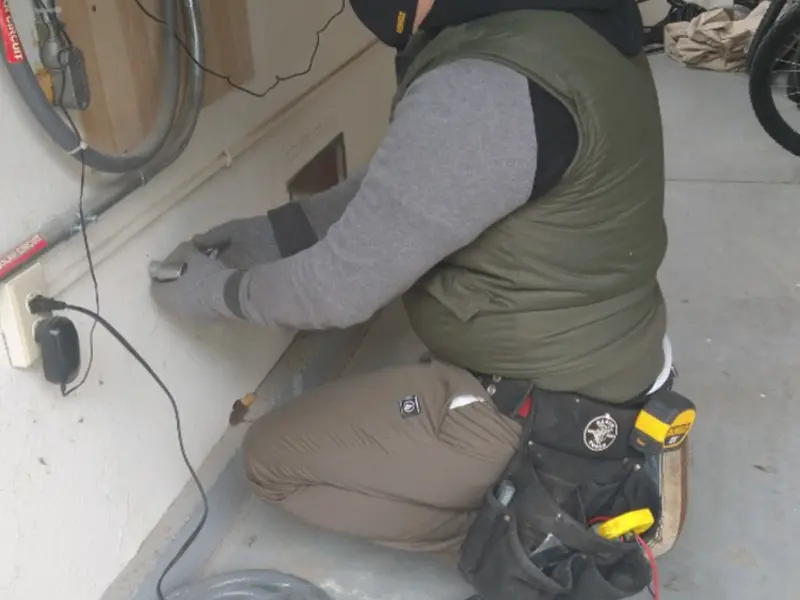 Electrician performing outlet wiring in a Evans garage